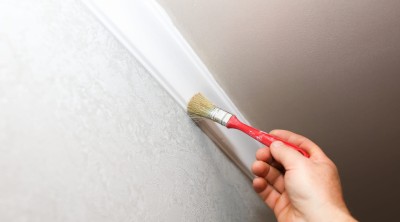 man-is-painting-gypsum-baseboard-with-brush-ceiling-maintenance-repair-works-flat-restoration-indoors-drywall-panel.jpg
